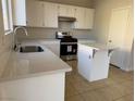 Bright kitchen with stainless steel appliances, white cabinets, and an eat-in kitchen island at 6024 Ripple Cloud Ct, North Las Vegas, NV 89031