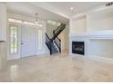 Bright living room featuring tile floors, a fireplace, and an elegant staircase at 8040 Arcadian Ln, Las Vegas, NV 89147