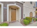 Inviting front entrance with desert landscaping, leading to a cozy condo unit with stylish accents and natural light at 9303 Gilcrease Ave # 1002, Las Vegas, NV 89149