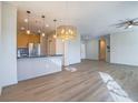 Open-concept living room featuring hardwood flooring, contemporary lighting, and a seamless flow into the kitchen at 1510 Fieldbrook St, Henderson, NV 89052