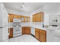 Bright kitchen with wood cabinets, white appliances and countertops with adjacent breakfast bar at 1830 N Buffalo Dr # 2014, Las Vegas, NV 89128