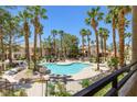 Community pool area surrounded by palm trees offering a relaxing outdoor space at 1830 N Buffalo Dr # 2014, Las Vegas, NV 89128