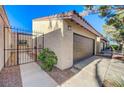 A single-story home with stucco exterior, a brown garage door and an enclosed courtyard entryway at 1850 Camino Verde Ln, Las Vegas, NV 89119