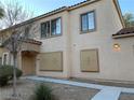 Desert townhome showcases a stucco exterior with tiled roof, desert landscaping, and gated windows at 2121 Hussium Hills St # 107, Las Vegas, NV 89108