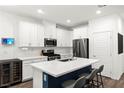 Modern kitchen featuring stainless steel appliances, white cabinets, quartz countertops, and a kitchen island with seating at 25 Barbara Ln # 36, Las Vegas, NV 89183