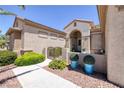 Inviting front entrance with a landscaped walkway, gated courtyard, and charming architectural details at 2752 Fort Myer Ave, Henderson, NV 89052