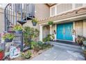 Inviting front porch with a blue door, lush greenery, and a decorative spiral staircase at 3617 Dutch Valley Dr, Las Vegas, NV 89147