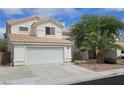 Exterior view of white home with two-car garage, tile roof and desert landscaping at 3750 Morning Canyon St, Las Vegas, NV 89147