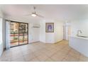 Bright living room featuring tile floors, a modern ceiling fan, and a sliding glass door for natural light at 440 Elm Dr # 103, Las Vegas, NV 89169