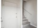 A clean entryway with a white door and neutral color palette, stairs leading up to the living area at 4675 Color Up Ct # 101, Las Vegas, NV 89122