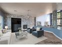Cozy living room with a stone accent wall, modern fireplace, and a comfortable seating arrangement at 5210 Villa Dante Ave, Las Vegas, NV 89141