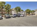 Exterior shot of complex with ample parking, and lush landscaping with mature trees at 5241 Caspian Springs Dr # 203, Las Vegas, NV 89120
