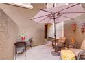 Private courtyard featuring outdoor seating, an umbrella, and a vibrant tiki decoration at 5465 Cardinal Ridge Ct # 103, Las Vegas, NV 89149