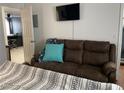 Bedroom features a comfortable brown couch and mounted TV, creating a relaxing space at 5576 W Rochelle Ave # 13A, Las Vegas, NV 89103