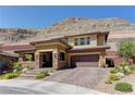 Attractive two-story home features desert landscaping and a mountain backdrop with a three-car garage at 5635 Mesa Mountain Dr, Las Vegas, NV 89135