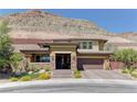 Beautiful two-story home boasts desert landscaping and a mountain backdrop, with a three-car garage at 5635 Mesa Mountain Dr, Las Vegas, NV 89135