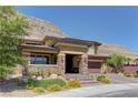 Charming home features desert landscaping and a mountain backdrop, complemented by a paver driveway at 5635 Mesa Mountain Dr, Las Vegas, NV 89135