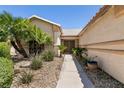 Inviting single-story home features a landscaped front yard with mature palm trees and desert plants at 5824 Kane Holly St, Las Vegas, NV 89130