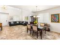 Bright living room with tiled floors, a decorative chandelier, and a cozy dining area at 749 Middle Beach St, Las Vegas, NV 89138