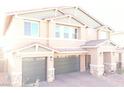 Charming two-story home with a three-car garage, a stone veneer and a well manicured brick driveway at 7855 Skyler Falls Ln, North Las Vegas, NV 89084