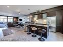 An open-concept kitchen with stainless steel appliances, island seating, and a cozy living space at 8925 W Flamingo Rd # 117, Las Vegas, NV 89147
