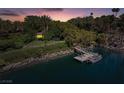 Aerial view of a private dock and boat on a tranquil lake surrounded by lush greenery at 1 Via Mira Monte, Henderson, NV 89011