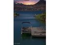 Peaceful lakeside dock with a boat, seating, and scenic views of the water and mountains at 1 Via Mira Monte, Henderson, NV 89011