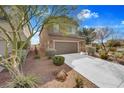 Two-story home with a two-car garage and low maintenance desert landscaping at 1104 Aspen Cliff Dr, Henderson, NV 89011
