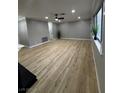 Living room with light wood floors, ceiling fan and large windows at 150 Greenbriar Townhouse Way, Las Vegas, NV 89121