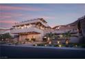 Three-story home with manicured grounds and a mountain view featuring a large driveway and exterior lighting at 1683 Tangiers Dr, Henderson, NV 89012