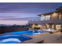 Backyard pool with a jacuzzi and lounge chairs with a view of mountains and a cloudy sky at 1683 Tangiers Dr, Henderson, NV 89012