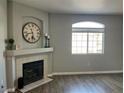 Living room with fireplace, mantel, and a large window allowing natural light to illuminate the space at 1830 N Buffalo Dr # 2022, Las Vegas, NV 89128