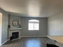 Spacious living room featuring a cozy fireplace, a window with natural light, and durable hardwood flooring at 1830 N Buffalo Dr # 2022, Las Vegas, NV 89128