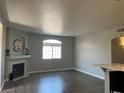 Open-concept living space with fireplace, hardwood flooring, and a sunlit window at 1830 N Buffalo Dr # 2022, Las Vegas, NV 89128