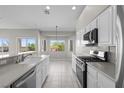Bright kitchen with stainless steel appliances, white cabinets, and scenic backyard views at 2158 Shubert Ave, Henderson, NV 89052