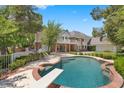 Backyard pool with diving board, surrounded by a brick border and lush landscaping at 3102 La Mirada Ave, Las Vegas, NV 89120