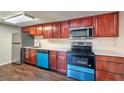 Well-lit kitchen featuring cherry wood cabinets, stainless steel appliances, and white countertops at 5021 River Glen Dr # 45, Las Vegas, NV 89103