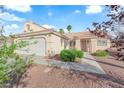 Single story home featuring desert landscaping, a two car garage, and a light colored exterior at 6231 Curlew Dr, Las Vegas, NV 89122
