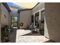 Private outdoor patio with pavers, shaded area, and an iron gate to the backyard at 7072 Arabian Ridge St, Las Vegas, NV 89131