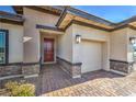 Close up of the home's front entrance and garage, with brick driveway at 1044 Forest Falcon Dr, Henderson, NV 89011