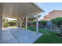 Large covered patio, green lawn and landscaped garden beds offer serene outdoor living at 1409 Basin Brook Dr, North Las Vegas, NV 89032