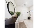 Modern entryway features a large round mirror, console table, decorative accents, and a neutral-toned rug at 1885 Vass Springs Pl, North Las Vegas, NV 89084