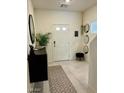 Bright foyer features neutral tones, patterned rug, updated lighting, and a convenient coat closet at 1885 Vass Springs Pl, North Las Vegas, NV 89084