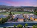 Stunning aerial view of a house in a golf course community with lush landscaping and mountain views at 20 Kittansett Loop, Henderson, NV 89052