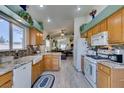 Bright kitchen with wooden cabinetry, granite countertops, stainless appliances, and a breakfast bar at 2200 Valley Heights Ave, Henderson, NV 89052