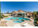 Gorgeous backyard features a sparkling pool and spa with rock accents, surrounded by lush landscaping and patio at 2200 Valley Heights Ave, Henderson, NV 89052