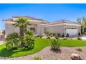 Attractive one-story home boasting a tile roof, three-car garage and desert landscaping with green turf at 3028 Treesdale Dr, Las Vegas, NV 89134