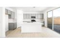 Modern kitchen with white countertops, an island, stainless appliances, gray cabinetry, and a sliding glass door at 336 Taylor St, Henderson, NV 89015