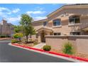 Condo exterior boasts a red-curbed street, mature tree, and inviting front entrance at 3950 S Sandhill Rd # 130, Las Vegas, NV 89121