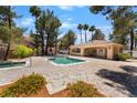 Community pool area with a pool house, lounge chairs and mature trees at 3950 S Sandhill Rd # 130, Las Vegas, NV 89121